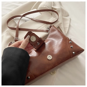 Detail of magnetic closure and silver rivets on brown vintage faux leather tote bag