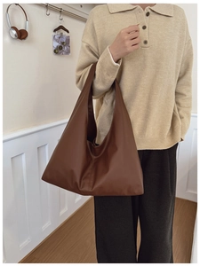 Detail of dark brown leather tote bag showing large capacity and minimalist design
