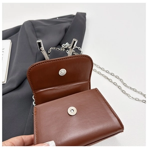 Détail du mini sac carré en cuir marron avec fermoir magnétique argenté et chaîne