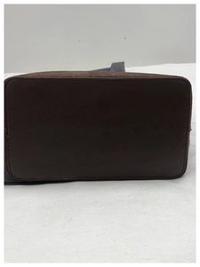 Détail de la base rectangulaire renforcée avec coutures précises d'un cabas en cuir marron