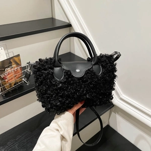 Chic black fuzzy plush handbag with leather trim and shoulder strap on stylish stairs