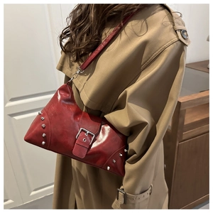 Detail of vintage burgundy tote bag with silver studs and metal buckle strap design