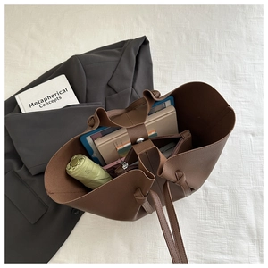 Brown leather tote bag interior view showing large capacity for tablet, umbrella and books