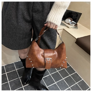 Close-up of brown vintage shell bag with silver studs and polished buckle details