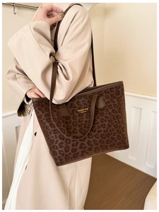 Brown leopard print tote bag with gold logo shown on model in a stylish trench coat