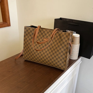 Vintage brown geometric print tote bag with top handles and adjustable strap in shop setting