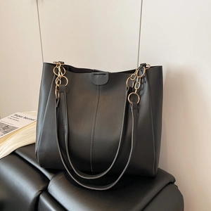 Large black leather tote bag with gold chain strap and magnetic buckle closure