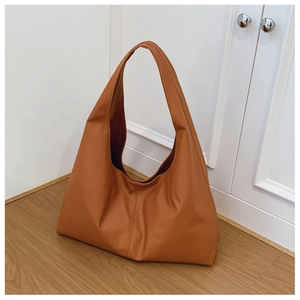 Detailed view of caramel brown hobo bag showing soft leather texture and wide strap design