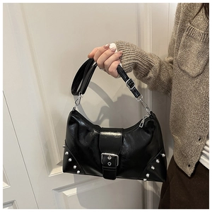 Detail of black leather shell bag with silver rivets and adjustable wide shoulder strap