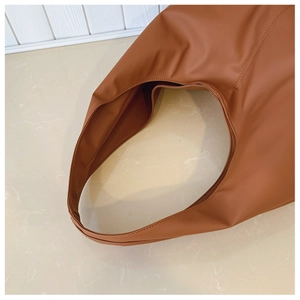 Detail of soft brown leather shoulder bag with seamless strap and fine stitching finish