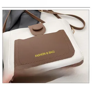 Dettaglio della borsa a tracolla bicolore in pelle con tasca frontale e logo