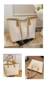 Detail of minimalist cream tote bag with brown handles and New York gold lettering