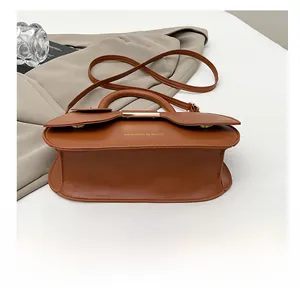 Detail of the caramel saddle bag showing the reinforced bottom and fashion branding