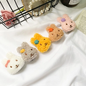 Close-up of five colorful plush bunny phone grips in soft faux lamb wool texture