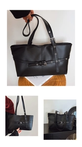Close-up of retro black faux leather tote bag with metal grommets and buckle details