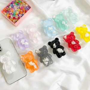 Detail of 3D bear phone socket grip featuring colorful glitter resin and folding design