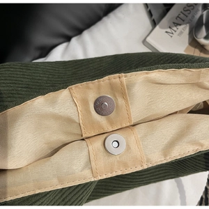 Gros plan d'un sac en velours côtelé vert foncé avec boucle magnétique argentée chic
