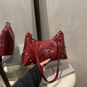 Deep red punk-style rivet shoulder bag in polished PU leather with large buckle detail