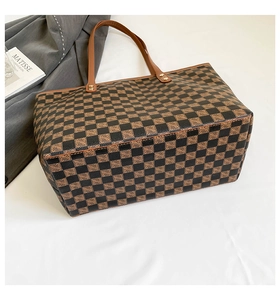 Dettaglio della grande borsa tote con motivo a scacchi vintage e manici in pelle