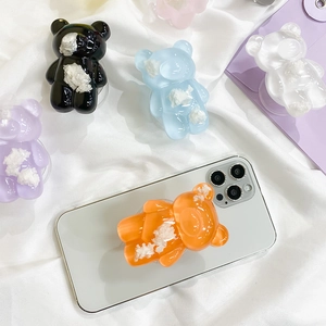 Close-up of cute transparent resin bear phone sockets in multiple colors on a phone