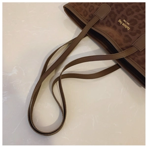 Detail of leopard print shoulder bag with gold New York lettering and leather straps
