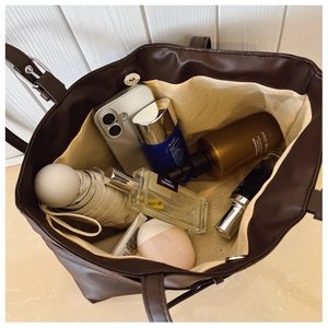 Deep brown tote bag showing spacious interior with magnetic buckle and daily essentials