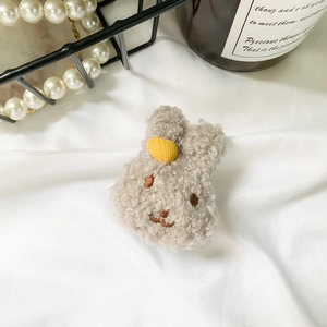 Close-up of cute grey plush bunny phone grip with a yellow heart on white fabric