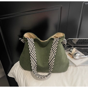 Détail du grand sac cabas en velours côtelé vert foncé avec une bandoulière tissée chic