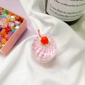Close-up of a pink jelly resin cherry cake phone grip on a white fabric background