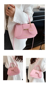 Detail showing pink leather handbag with gold hardware and stylish long shoulder strap