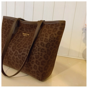 Close-up of brown leopard print tote bag with gold stamped fashion text logo detail