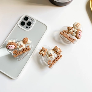 Détail d'un support de téléphone en cœur avec ours et breloques douces en résine