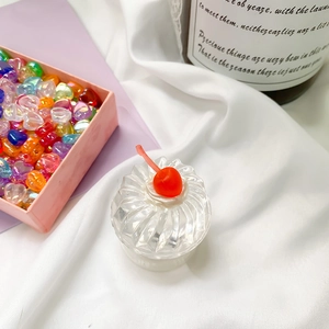 Macro shot of 3D transparent cherry cupcake resin container and heart beads for phone grip DIY