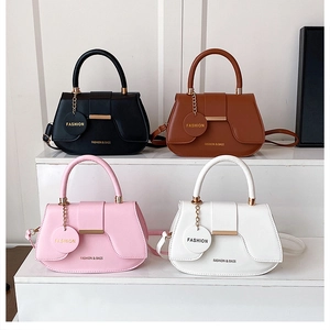 Multiple stylish women handbags in black, brown, pink, and white on a clean white display