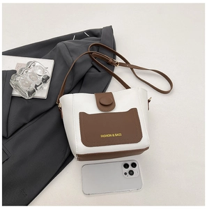 Dettaglio della borsa a secchiello bicolore con texture in pelle PU e chiusura magnetica