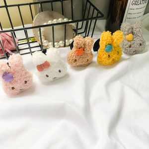 Close-up of five colorful plush bunny phone grips in pink, white, yellow, and grey colors