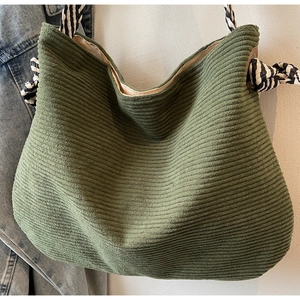 Détail du sac cabas en velours côtelé vert avec anse nouée rayée et texture nervurée