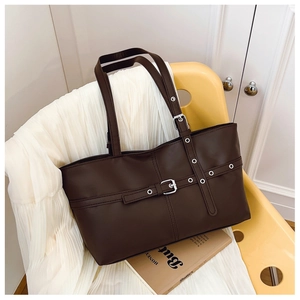 Detail view of dark coffee PU leather tote bag with silver buckle and decorative straps