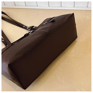 Macro side view of deep brown vintage tote bag with matte leather finish and silver hardware