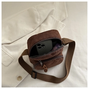 Macro detail of brown corduroy crossbody bag with zipper and spacious interior compartment