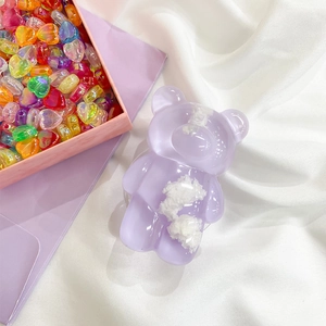 Detail shot of a purple translucent bear phone grip with cloud texture on white fabric