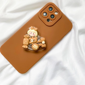 Detail of a brown phone case with a transparent heart grip and cute 3D cartoon charms