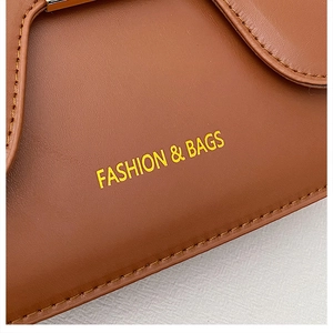 Close-up of brown leather saddle bag featuring fine stitching and gold buckle detail