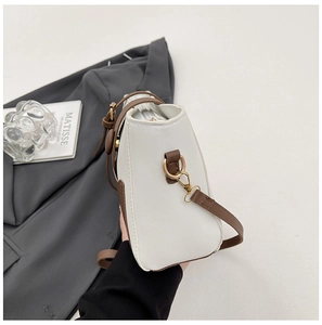 Dettaglio della borsa a tracolla in pelle con anello a D dorato e tracolla marrone chic