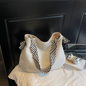 Grand sac cabas en velours côtelé beige avec bandoulière tissée et accessoires modernes