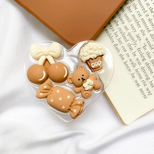 Detailed view of heart-shaped resin phone grip with 3D bear and dessert charms