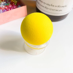 Macro shot of bright yellow spherical phone grip with soft flocking texture on a stand