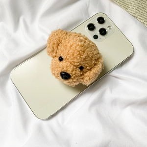 Close-up of cute brown plush teddy dog head phone grip on soft white fabric background