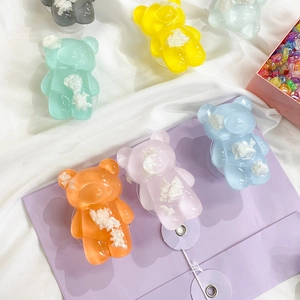 Close-up of colorful translucent resin bear phone grips with white cloud-like filling details