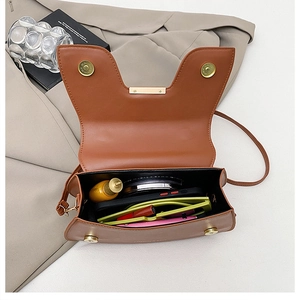 Internal view of brown leather saddle bag showing storage space for daily essentials